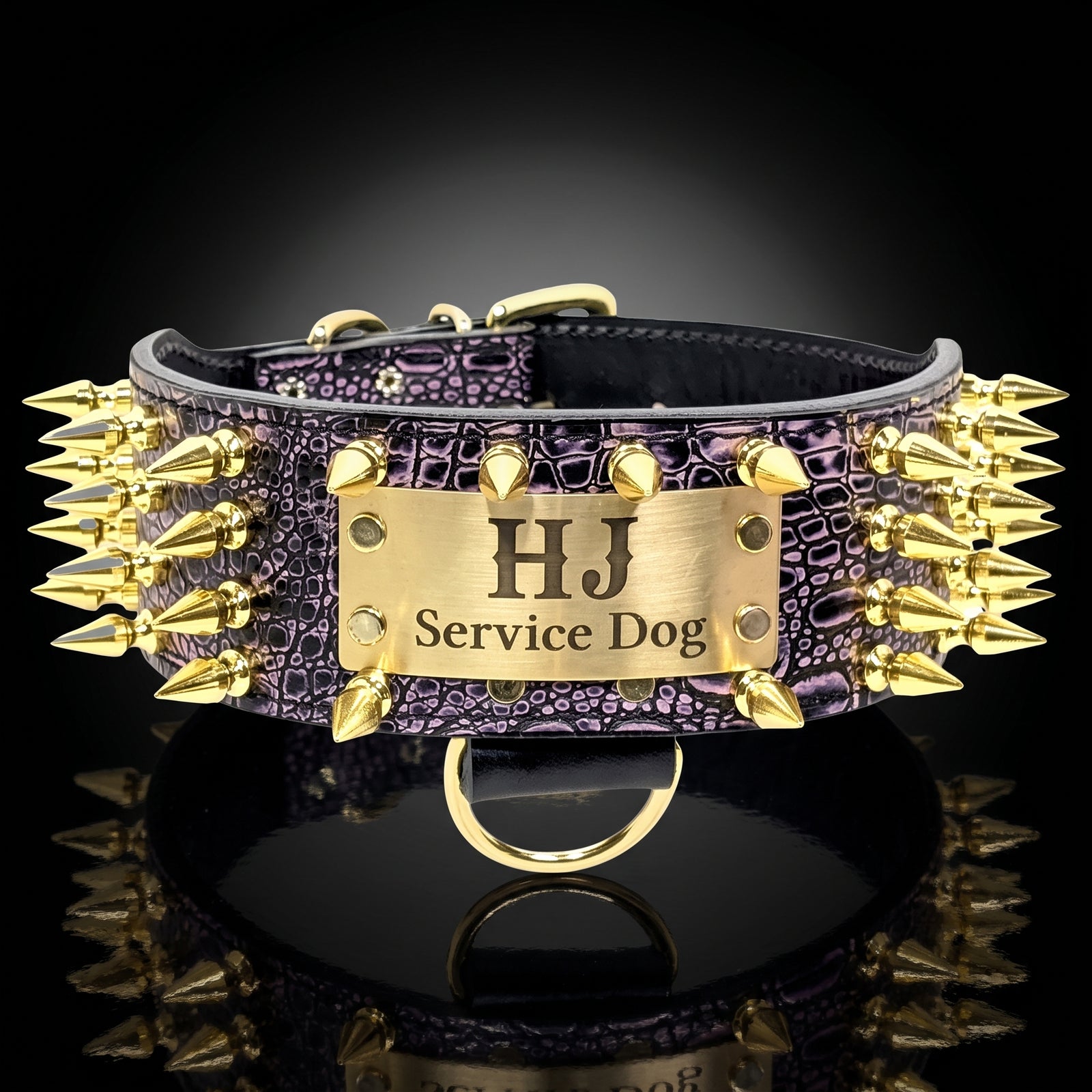 A custom dog collar with a purple crocodile-embossed leather strap, covered in gold spikes, and a central gold metal plate engraved with 'HJ Service Dog'.