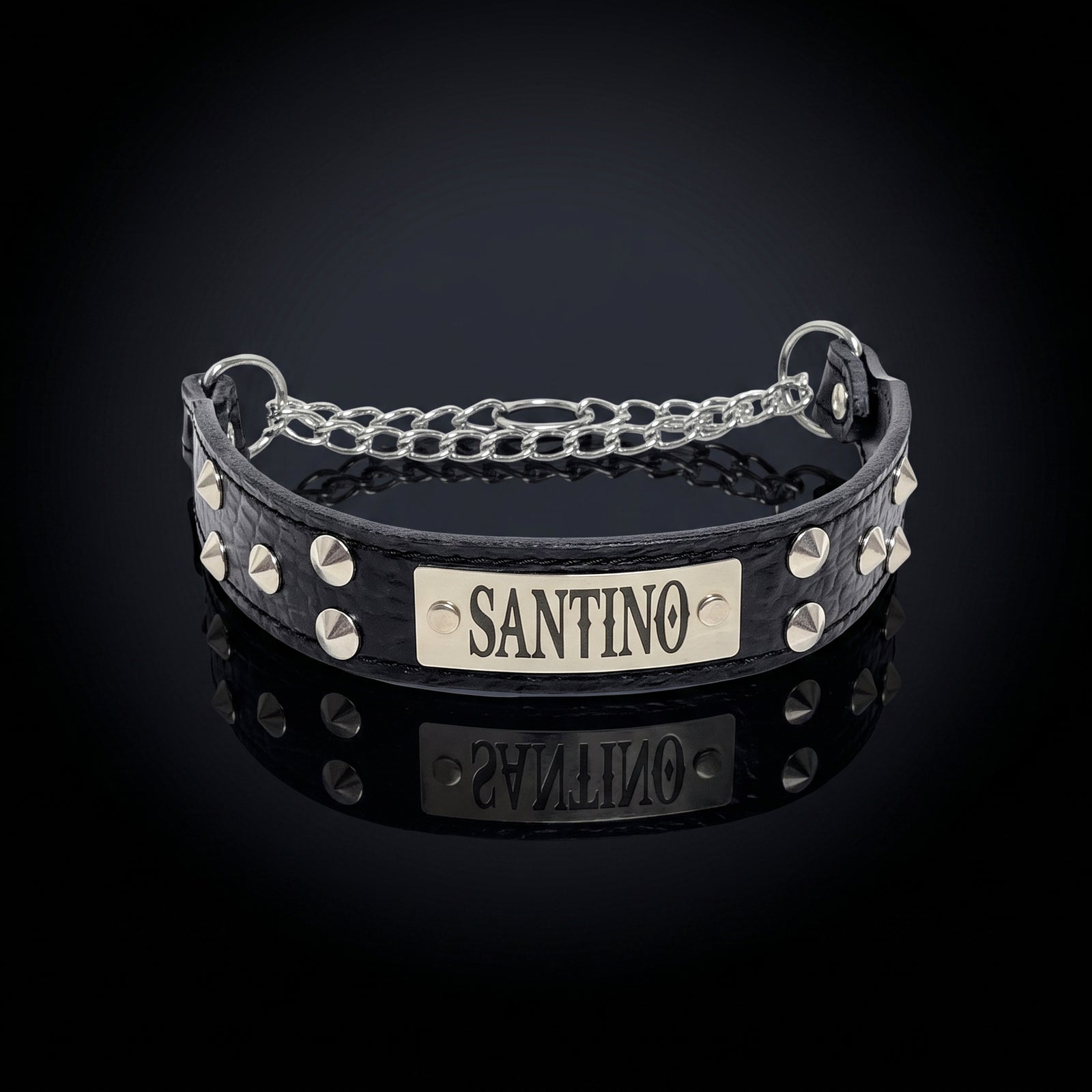 A black crocodile-embossed leather collar with silver studs and a silver chain, featuring a central silver plate engraved with the name 'SANTINO'.