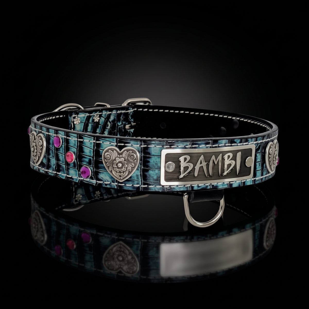 A custom pet collar with a distressed teal and black textured pattern, featuring silver heart-shaped metal studs, pink rhinestones, and a silver metal nameplate engraved with 'BAMBI'.
