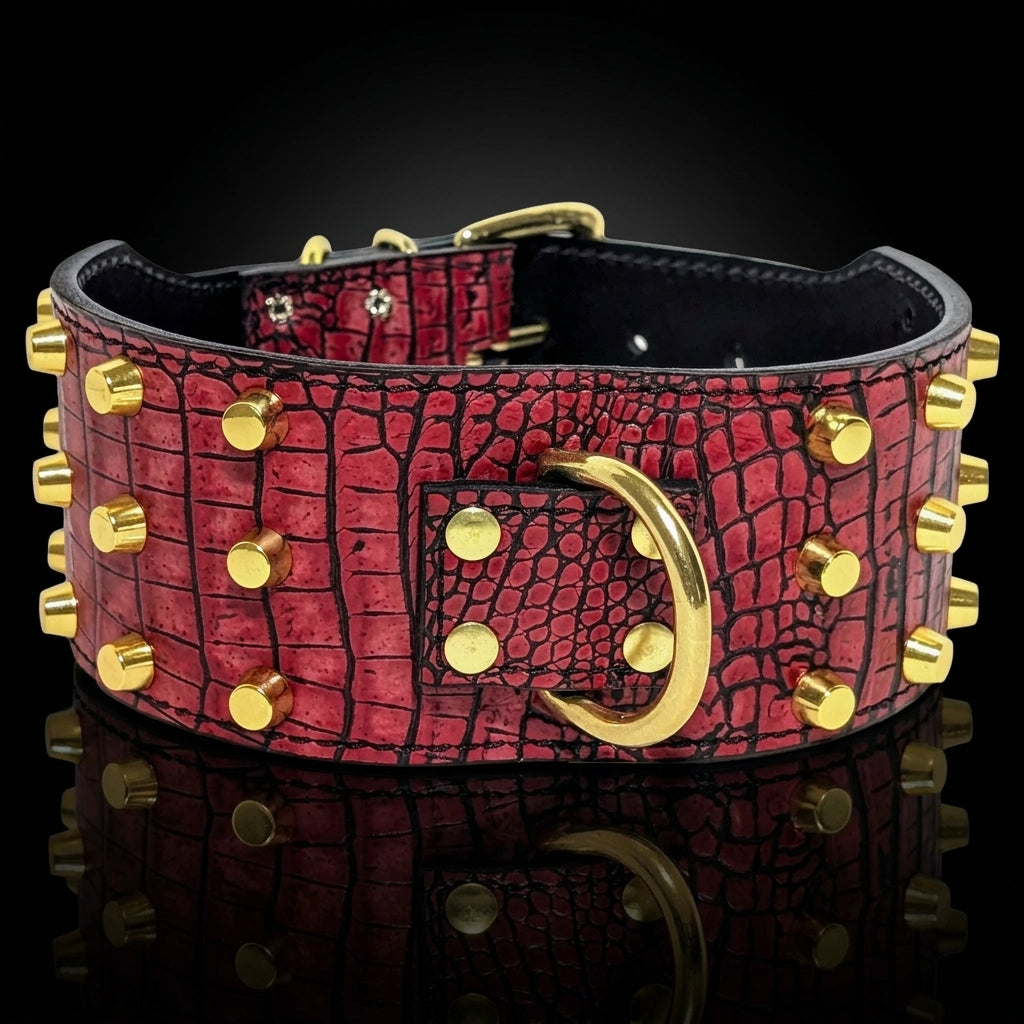 A red crocodile-embossed leather collar with gold-tone studs, a large gold ring buckle, and a black interior, shown on a reflective black background.