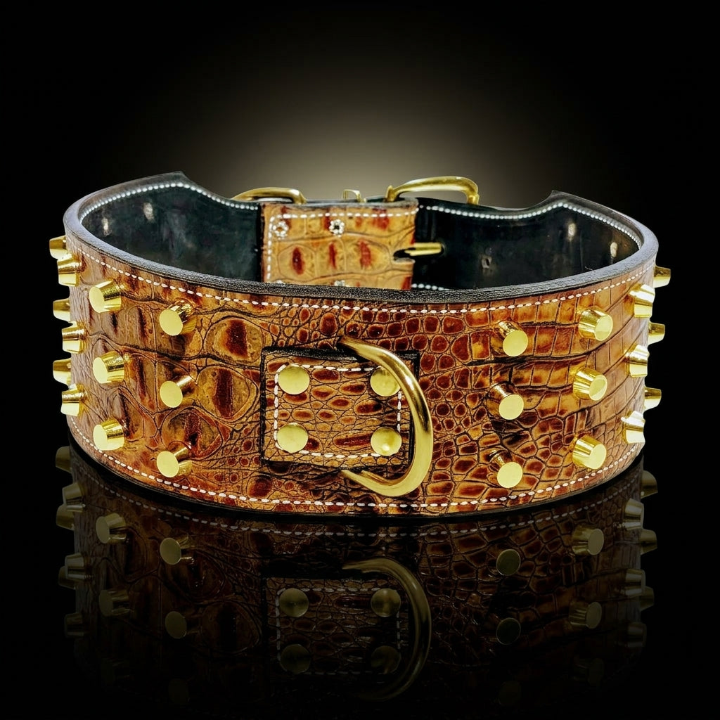 A brown crocodile-embossed leather collar with gold-tone studs and hardware, displayed on a reflective black surface against a dark background.