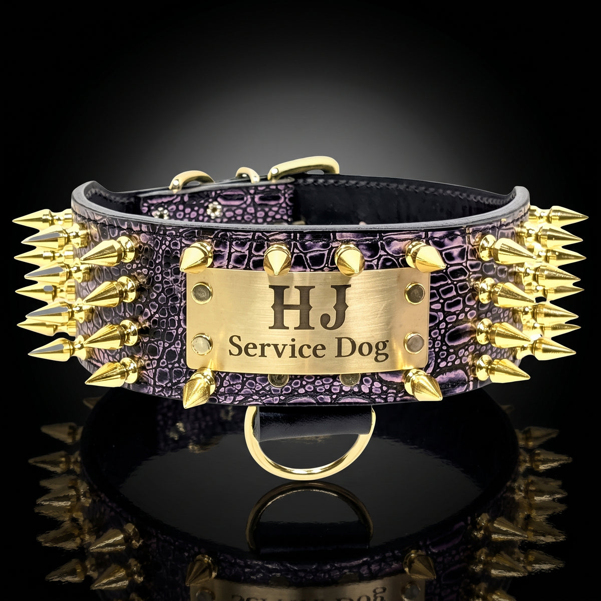A custom dog collar with a purple crocodile-embossed leather strap, covered in gold spikes, and a central gold metal plate engraved with 'HJ Service Dog'.