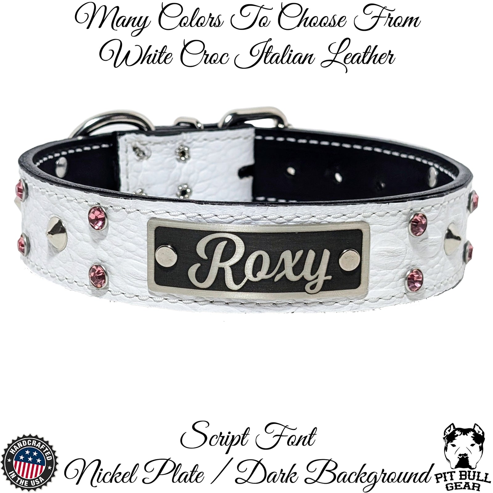 A white leather dog collar with cone studs and crystal gems, featuring a custom engraved name plate that reads 'Roxy'. The collar includes a roller buckle and a metal loop for leash attachment.