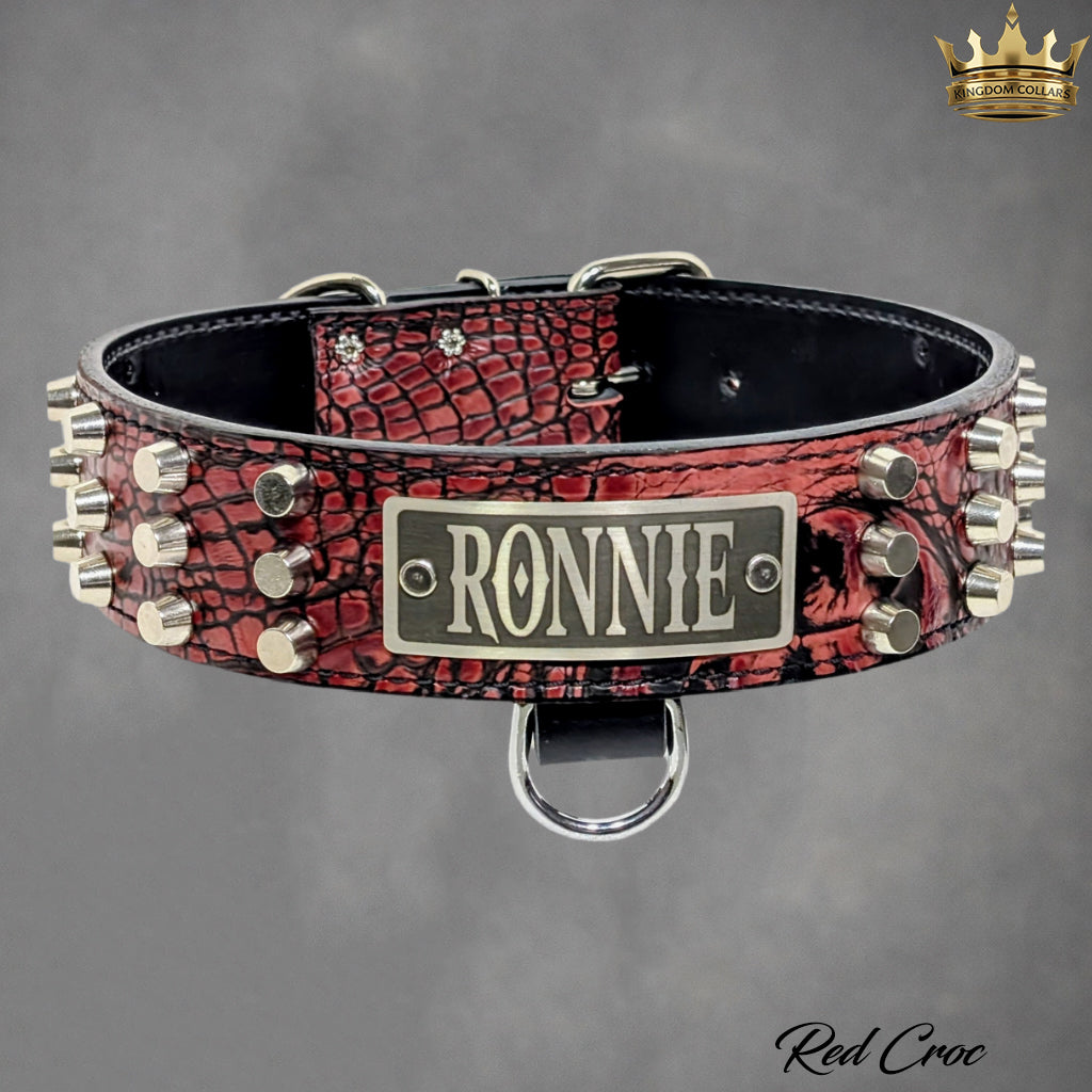 Red crocodile pattern dog collar with 'RONNIE' nameplate on a gray background