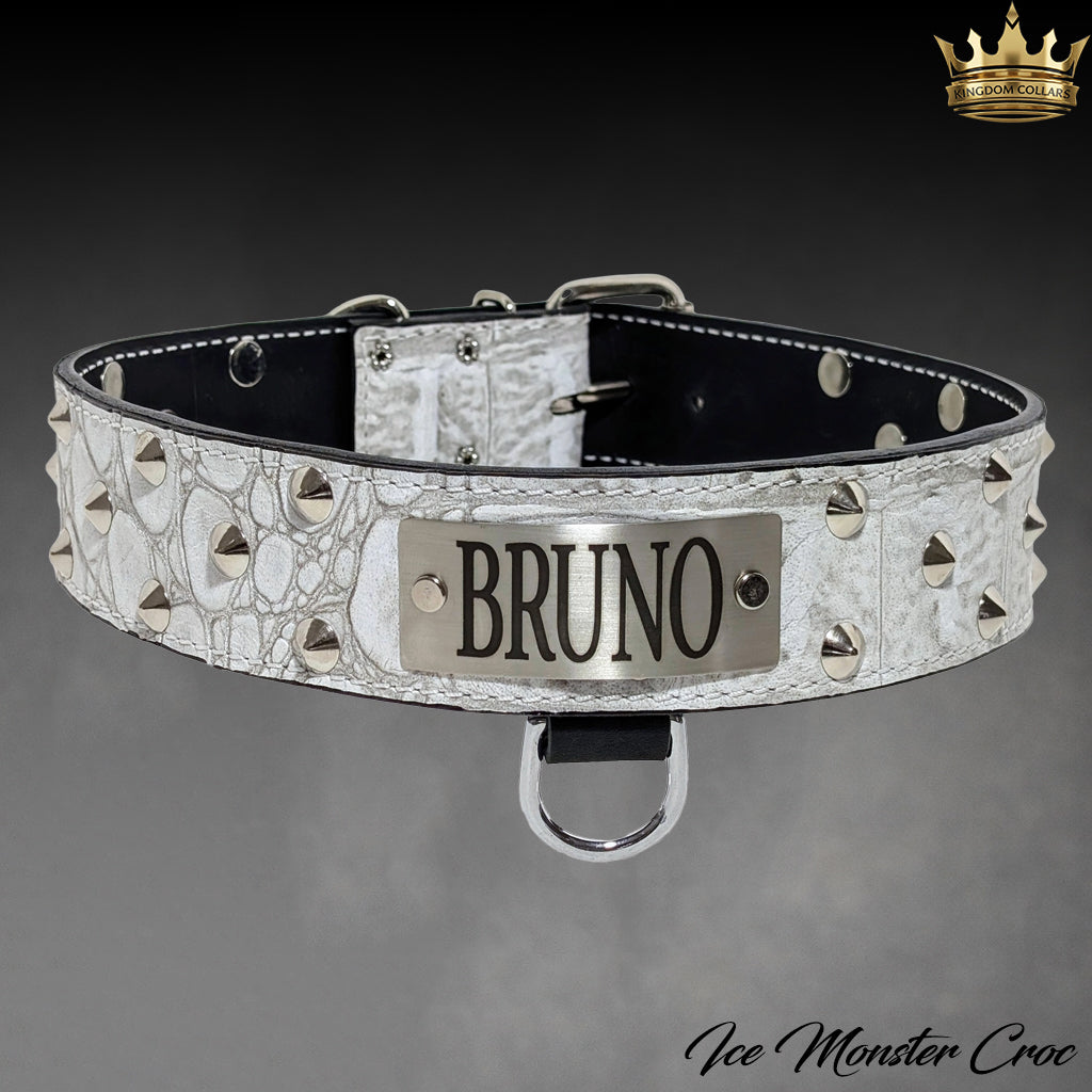 A white crocodile-embossed leather dog collar with silver studs and a central silver metal plate engraved with 'BRUNO'. The collar is displayed against a dark gray gradient background with a gold crown logo in the top right corner and 'Ice Monster Croc' text in the bottom right corner.