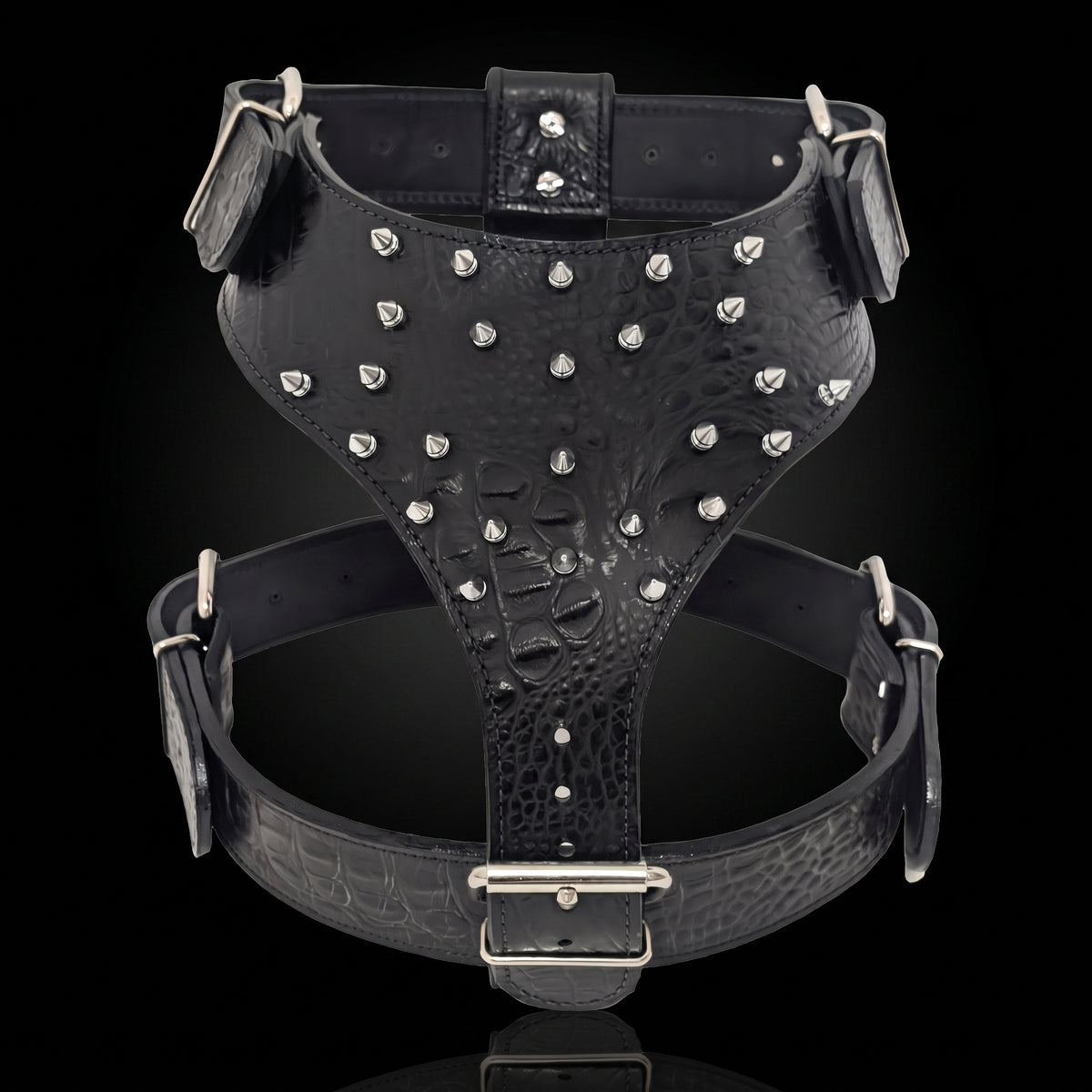 Black crocodile-embossed leather harness with silver studs and metal buckles, shown against a black background.