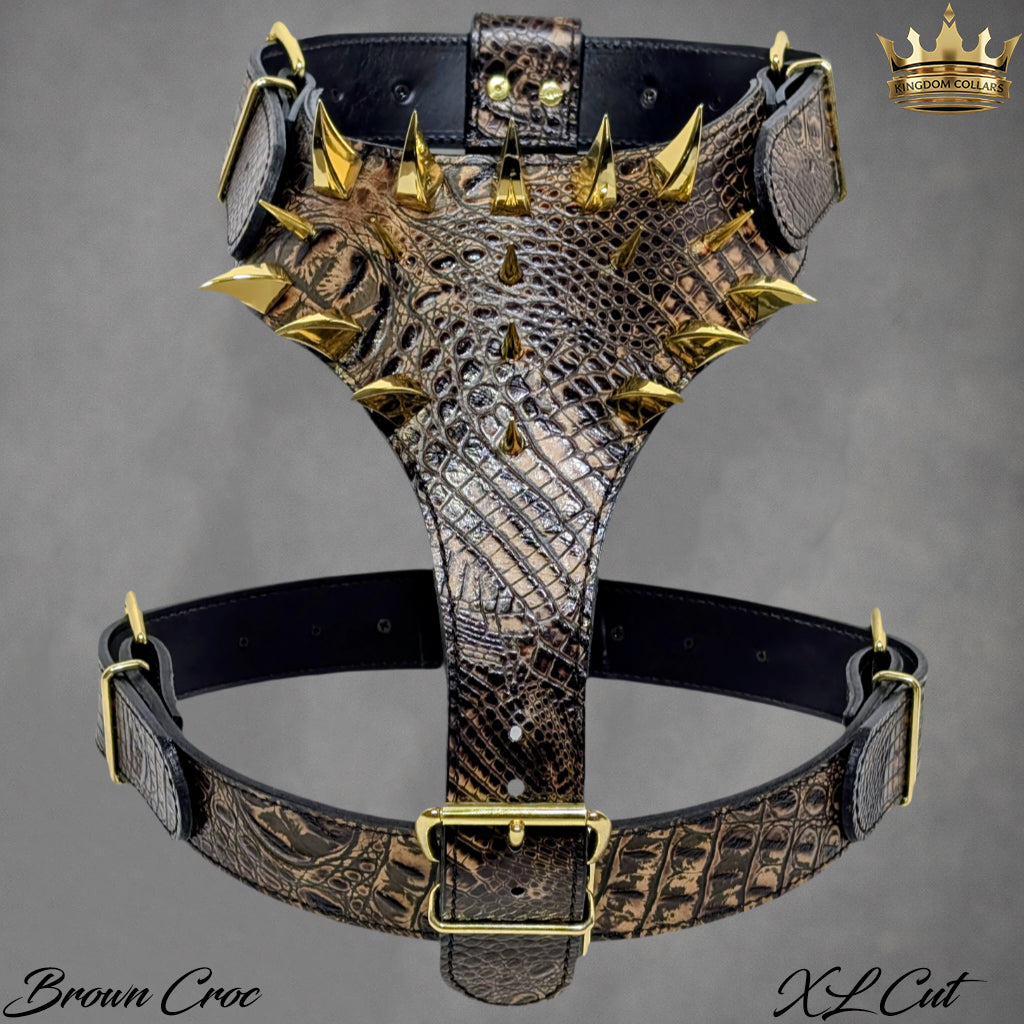 Brown crocodile pattern leather harness with gold spikes on a gray background