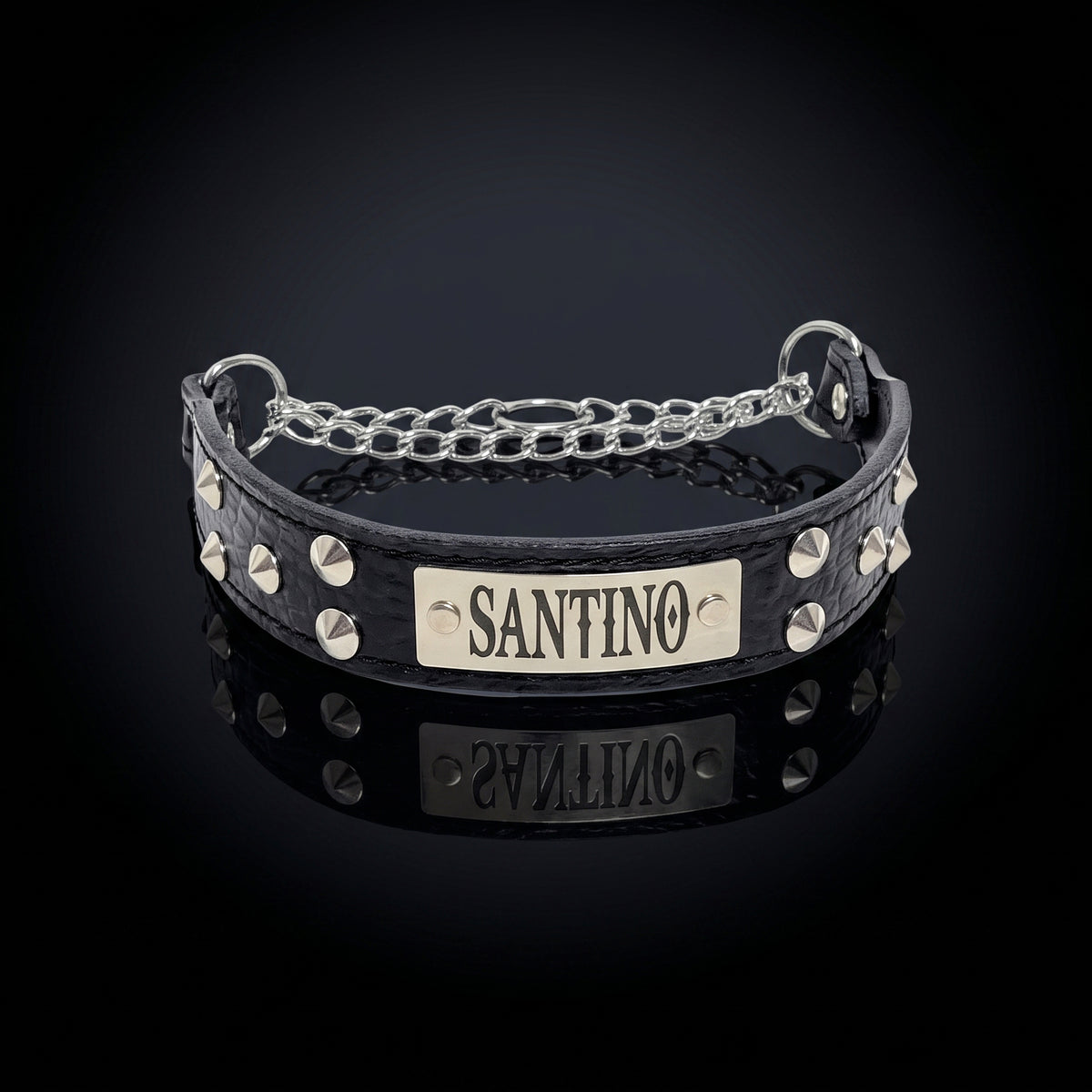 A black crocodile-embossed leather collar with silver studs and a silver chain, featuring a central silver plate engraved with the name 'SANTINO'.
